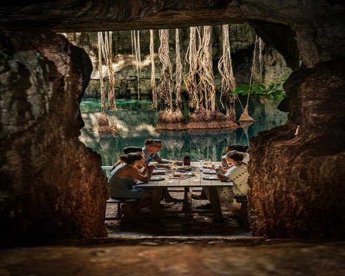 A family sitting around a rustic dining table outdoors sharing a quiet traditional lunch without electronic distractions
